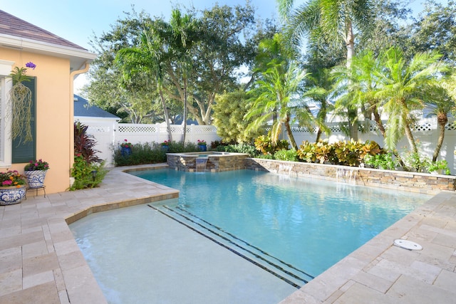 view of pool with a patio, pool water feature, and an in ground hot tub