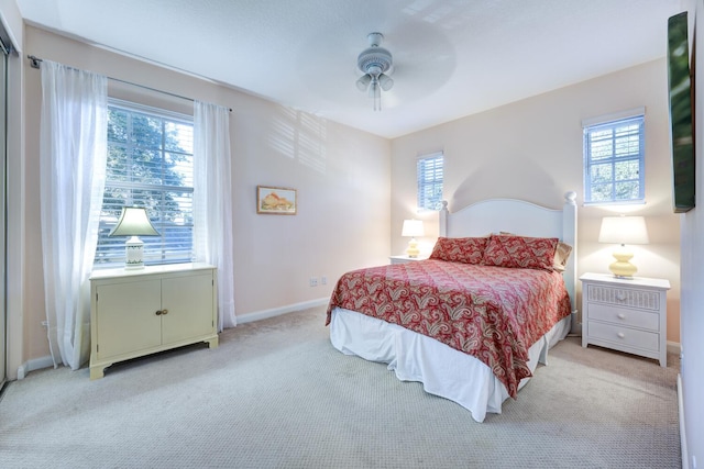 carpeted bedroom featuring multiple windows and ceiling fan