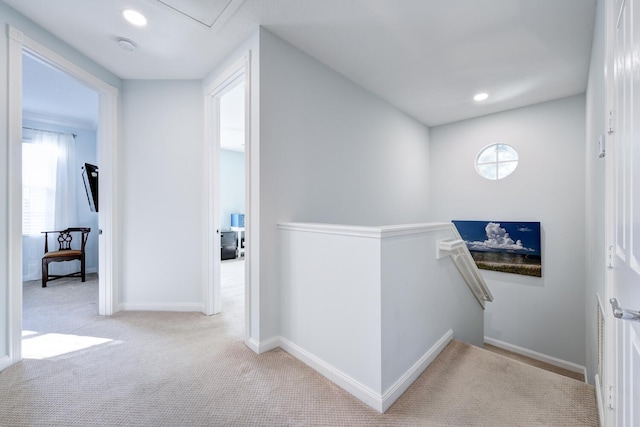 hallway featuring light colored carpet