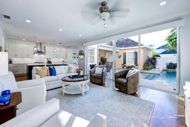 living room featuring ceiling fan, light hardwood / wood-style flooring, and crown molding