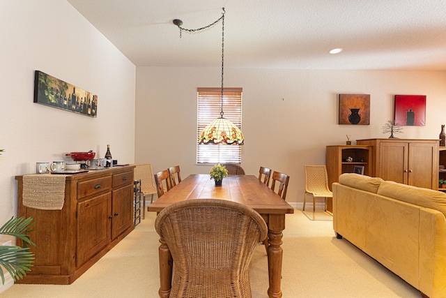 dining space featuring a textured ceiling and light carpet