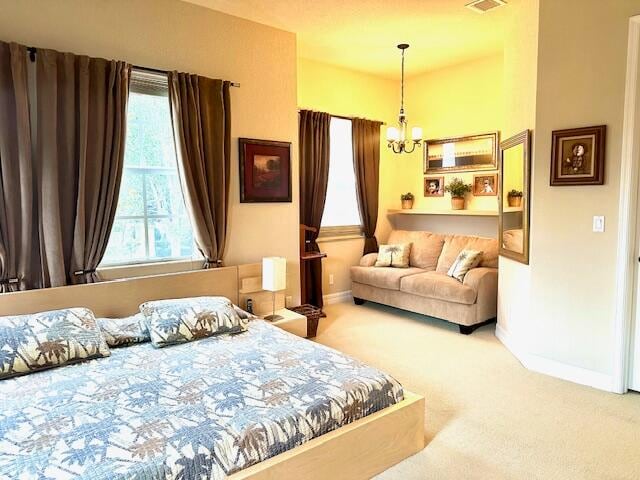 bedroom featuring carpet flooring and a chandelier