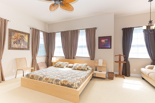 bedroom featuring ceiling fan with notable chandelier and carpet floors