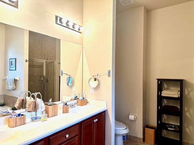 bathroom with toilet, vanity, and walk in shower