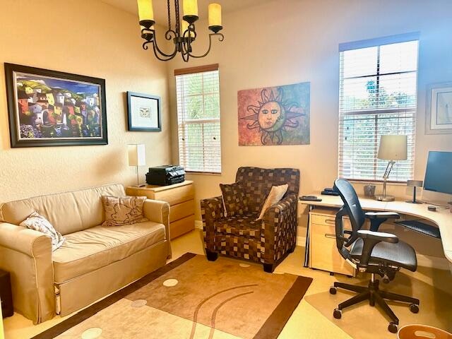 home office featuring plenty of natural light and a notable chandelier