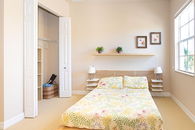 bedroom featuring light carpet and a closet