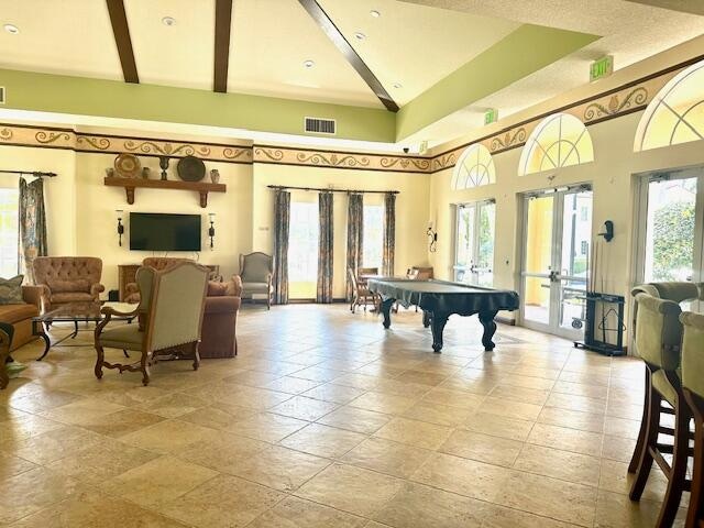 game room featuring beam ceiling, french doors, a towering ceiling, and pool table