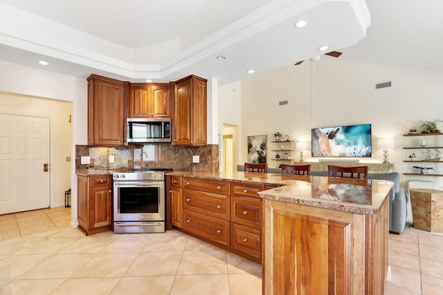 kitchen featuring kitchen peninsula, appliances with stainless steel finishes, light tile patterned floors, and light stone counters