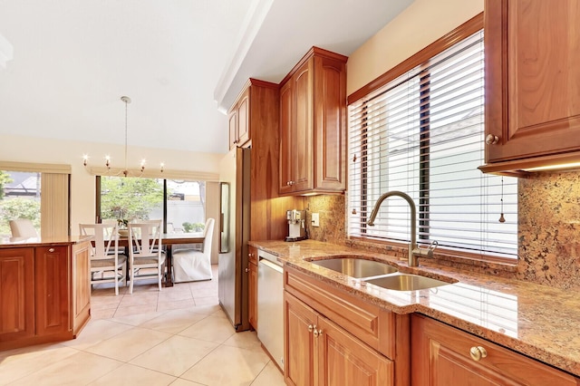 kitchen with light stone countertops, backsplash, sink, dishwasher, and hanging light fixtures