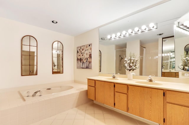 bathroom with tile patterned floors, vanity, and separate shower and tub