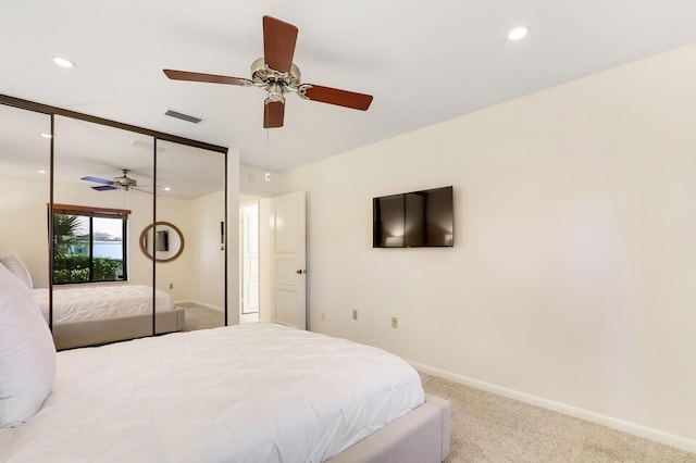 carpeted bedroom featuring ceiling fan and a closet