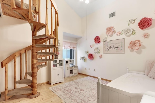 bedroom featuring light hardwood / wood-style floors and high vaulted ceiling