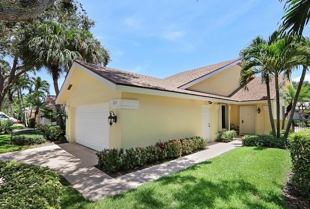 single story home with a garage and a front lawn