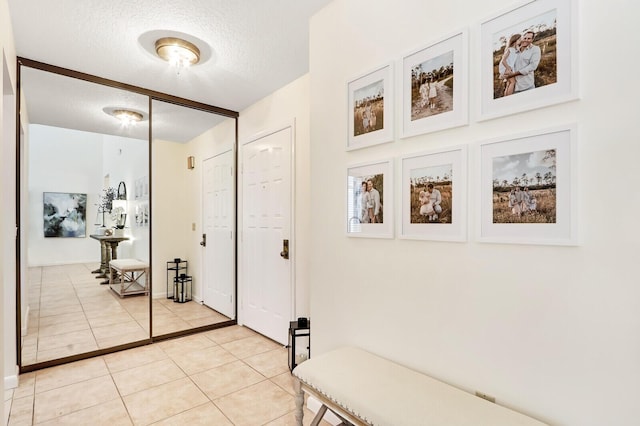 hall with light tile patterned floors and a textured ceiling