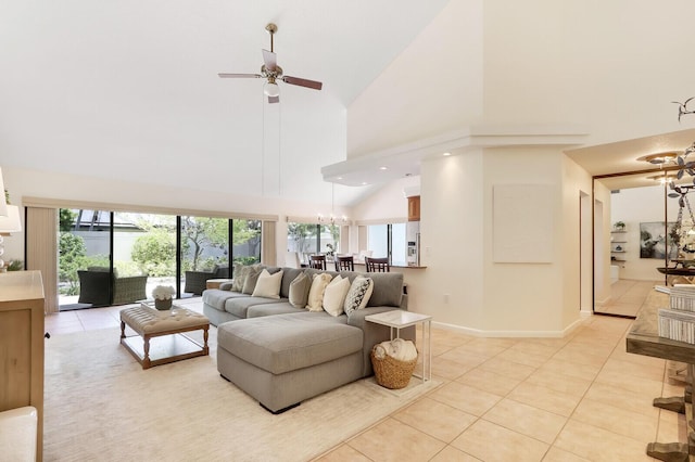 living room with ceiling fan with notable chandelier, light tile patterned floors, and high vaulted ceiling