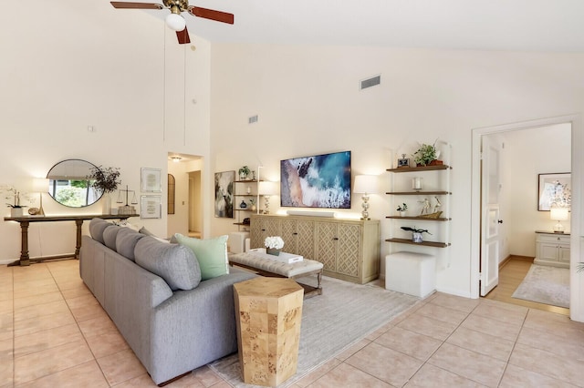 living room featuring ceiling fan, light tile patterned floors, and high vaulted ceiling