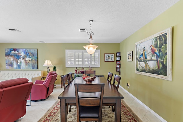 dining area with light tile patterned floors and a textured ceiling