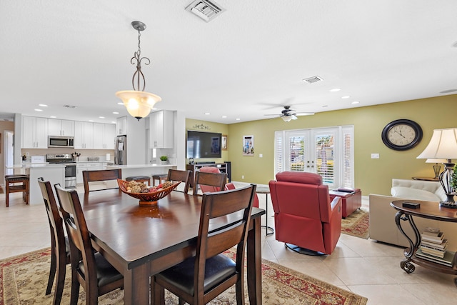 tiled dining area with ceiling fan and french doors