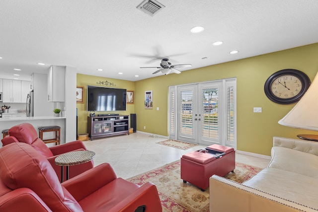 tiled living room with ceiling fan, a textured ceiling, and french doors