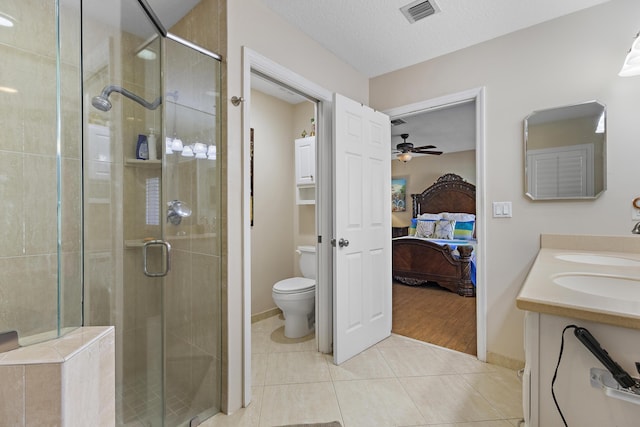 bathroom with tile patterned flooring, toilet, a textured ceiling, an enclosed shower, and vanity