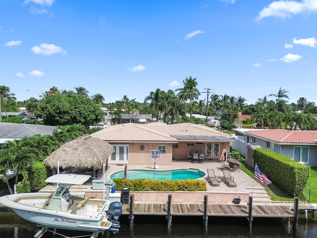 rear view of house featuring french doors, a water view, and a patio