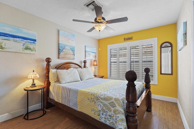 bedroom featuring a textured ceiling, ceiling fan, and wood-type flooring