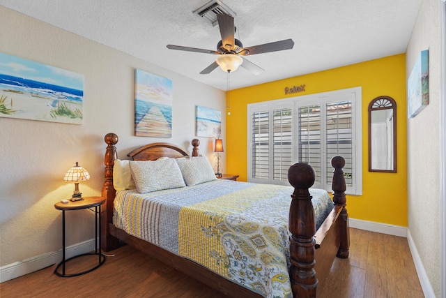 bedroom featuring ceiling fan, a textured ceiling, and hardwood / wood-style flooring