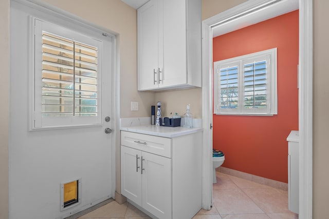 interior space with white cabinetry and light tile patterned floors