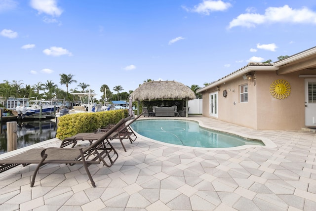 view of swimming pool featuring a patio, a water view, and a gazebo