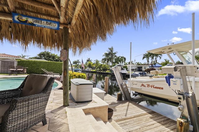 view of dock with a water view, a fenced in pool, and a patio