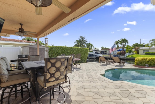 view of pool with a patio, a storage unit, and ceiling fan