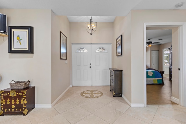 entrance foyer featuring light hardwood / wood-style flooring and ceiling fan with notable chandelier