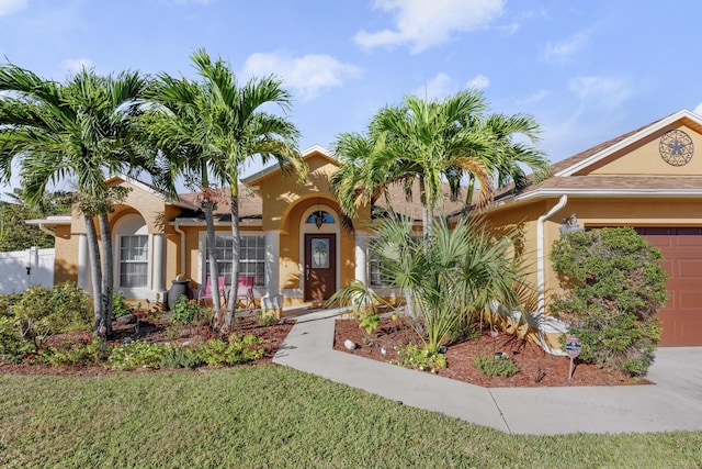 mediterranean / spanish house with a garage and a front yard