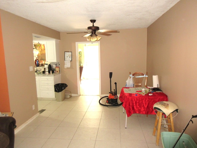 tiled dining room with ceiling fan and a textured ceiling