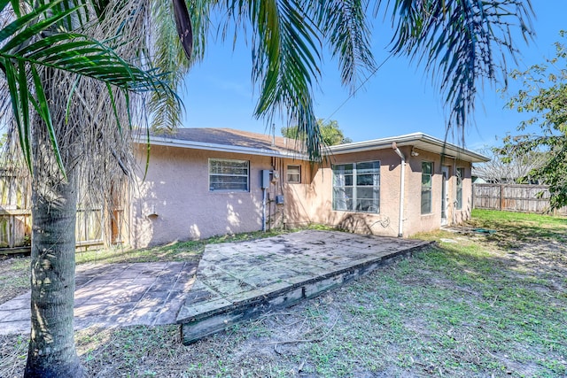 rear view of house with a lawn and a patio