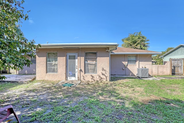 back of house featuring a yard and cooling unit