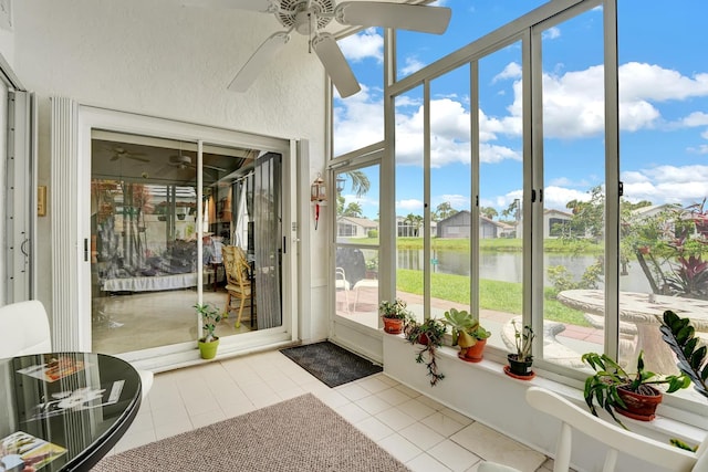 unfurnished sunroom with ceiling fan and a water view