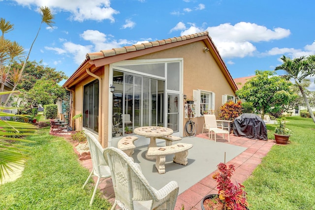 rear view of house with a yard and a patio