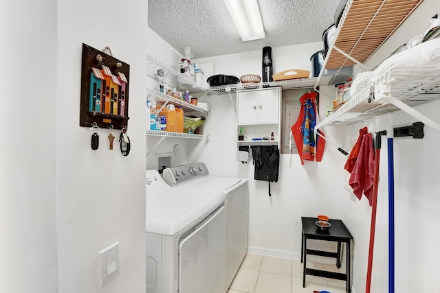 laundry room with a textured ceiling, separate washer and dryer, and light tile patterned flooring