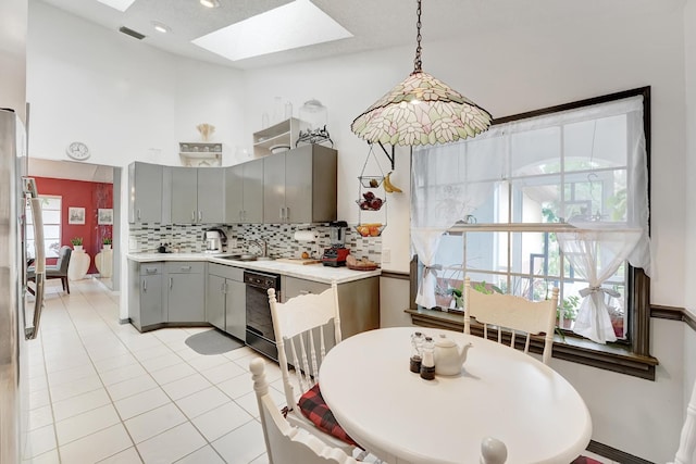 kitchen featuring gray cabinetry, sink, hanging light fixtures, a skylight, and black dishwasher