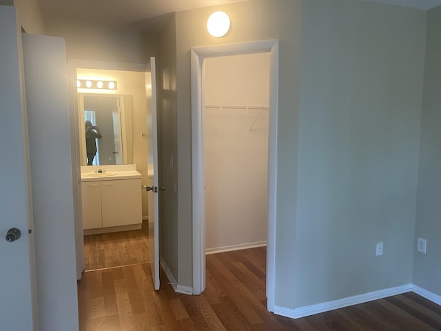 hall with sink and dark wood-type flooring