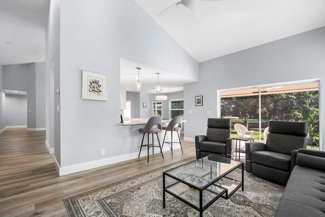 living room featuring ceiling fan, wood-type flooring, and high vaulted ceiling