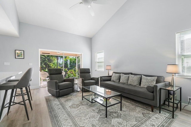 living room featuring a wealth of natural light, high vaulted ceiling, light hardwood / wood-style floors, and ceiling fan