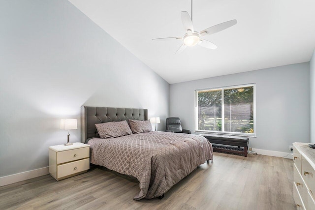 bedroom featuring light hardwood / wood-style floors, vaulted ceiling, and ceiling fan