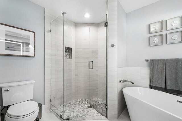 bathroom featuring shower with separate bathtub and toilet