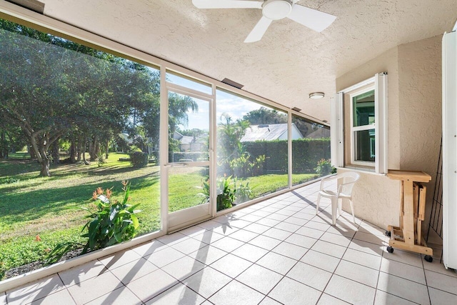 unfurnished sunroom with ceiling fan