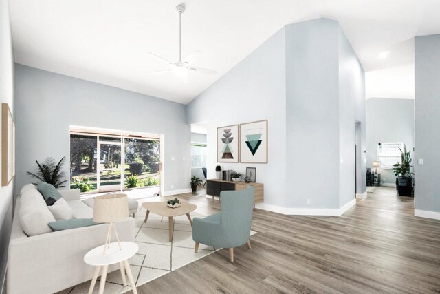 living room with ceiling fan, light hardwood / wood-style floors, and high vaulted ceiling