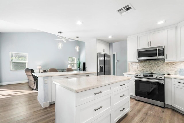 kitchen featuring white cabinets, appliances with stainless steel finishes, and light hardwood / wood-style flooring