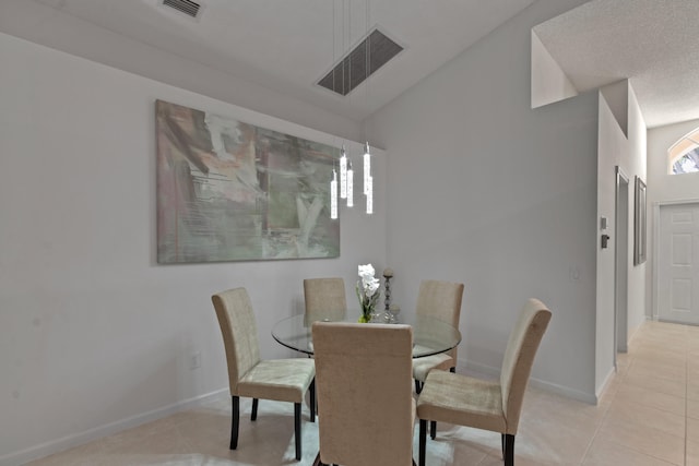 dining area with light tile patterned floors and lofted ceiling