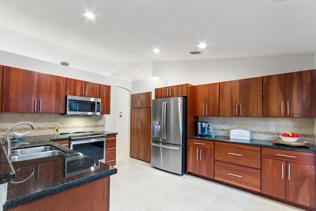 kitchen featuring decorative backsplash, sink, lofted ceiling, and stainless steel appliances